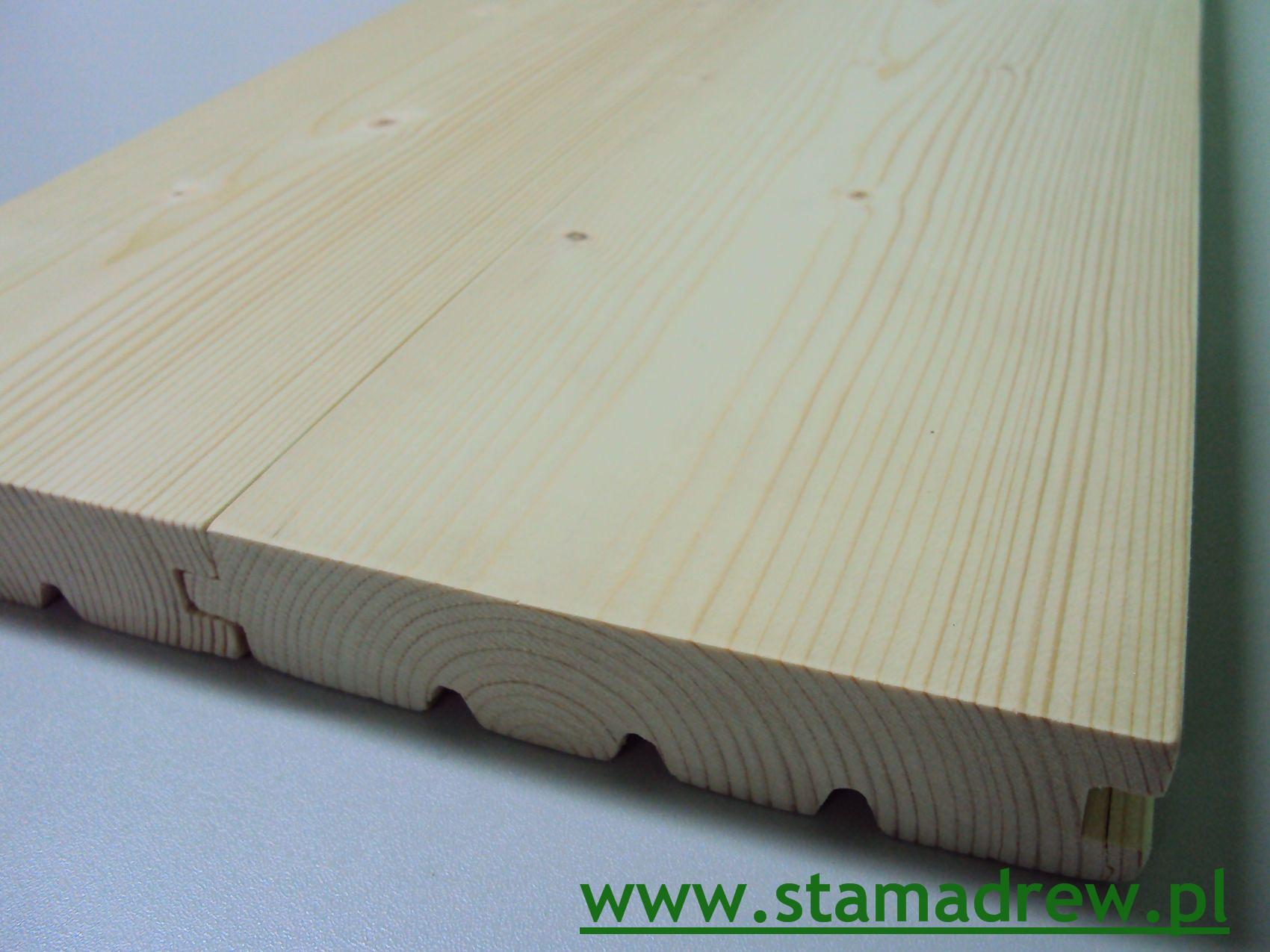 Jasne deski podłogowe z widocznym systemem łączenia pióro-wpust, ukazujące strukturę drewna w przekroju poprzecznym.